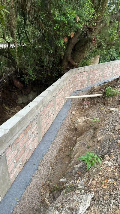 Muro de contenção concluído ao longo da mesma divisa, com dreno ao pé
